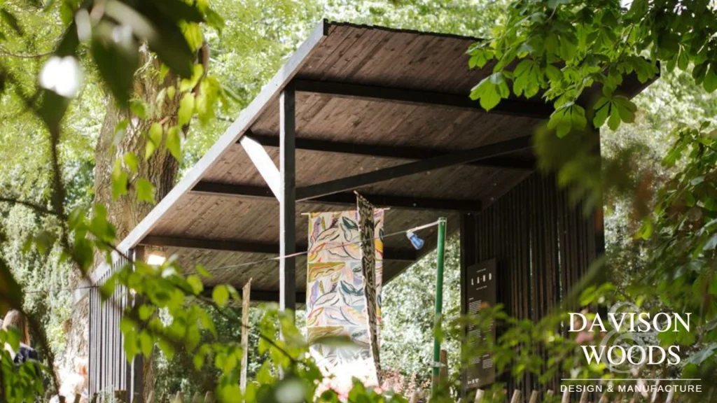 BSW outdoor exhibition, trees surround the dark wood stand