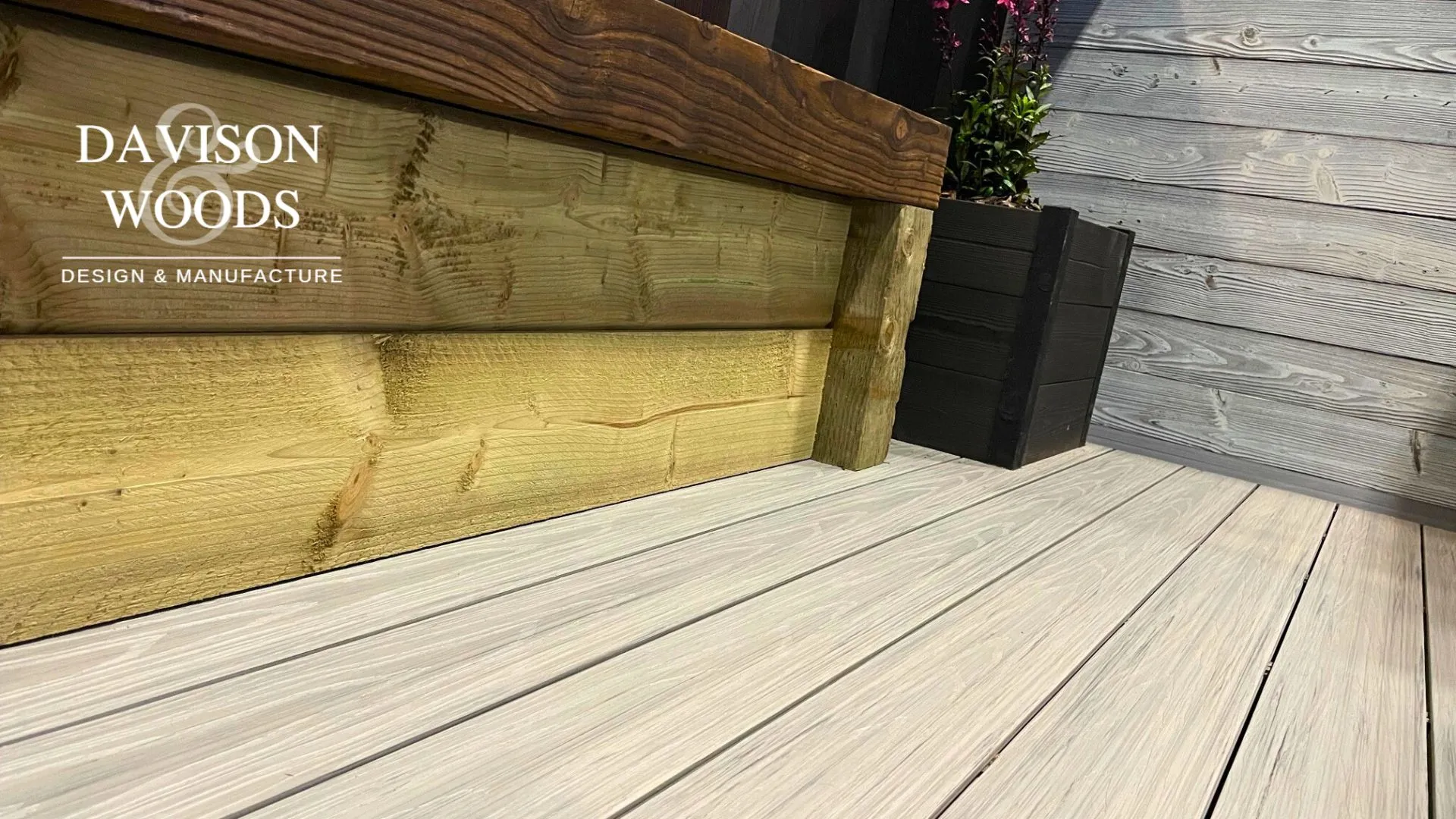 A BSW sleeper bench seat sits upon BSW decking in a close up shot highlighting the attractive wood colours and grain of each element.